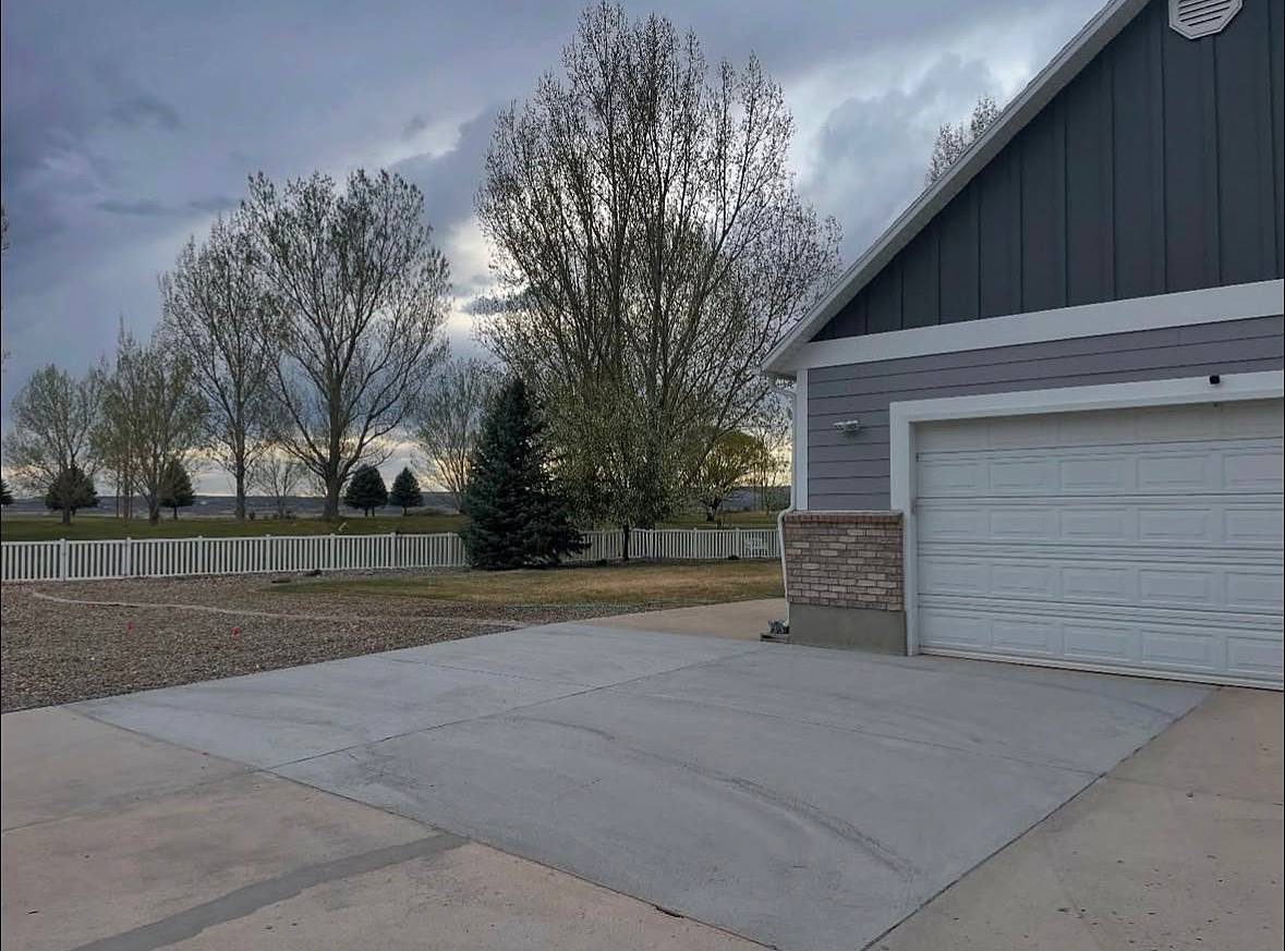 Finished concrete driveway slab in front of a grey garage in Roosevelt, Utah