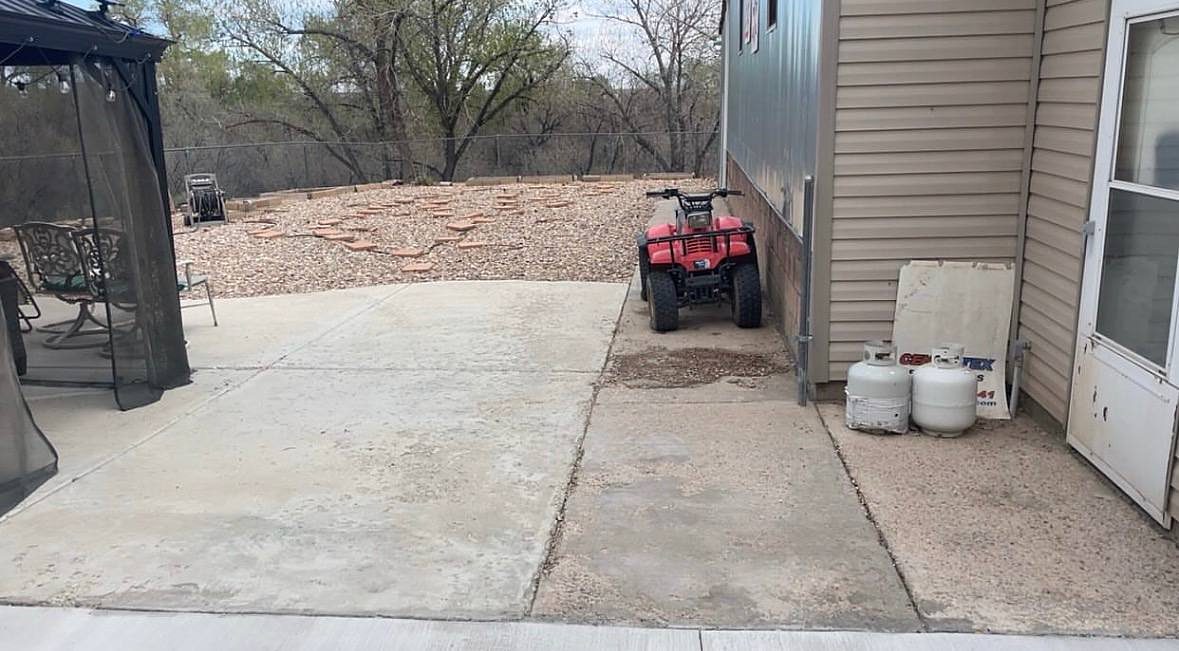 Weathered patio and side slab next to a house, before