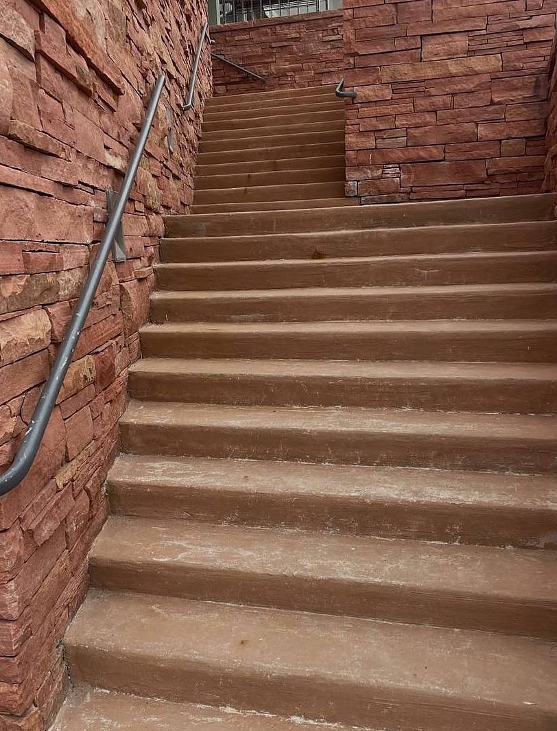 Faded red concrete steps with white staining and rust spots, before