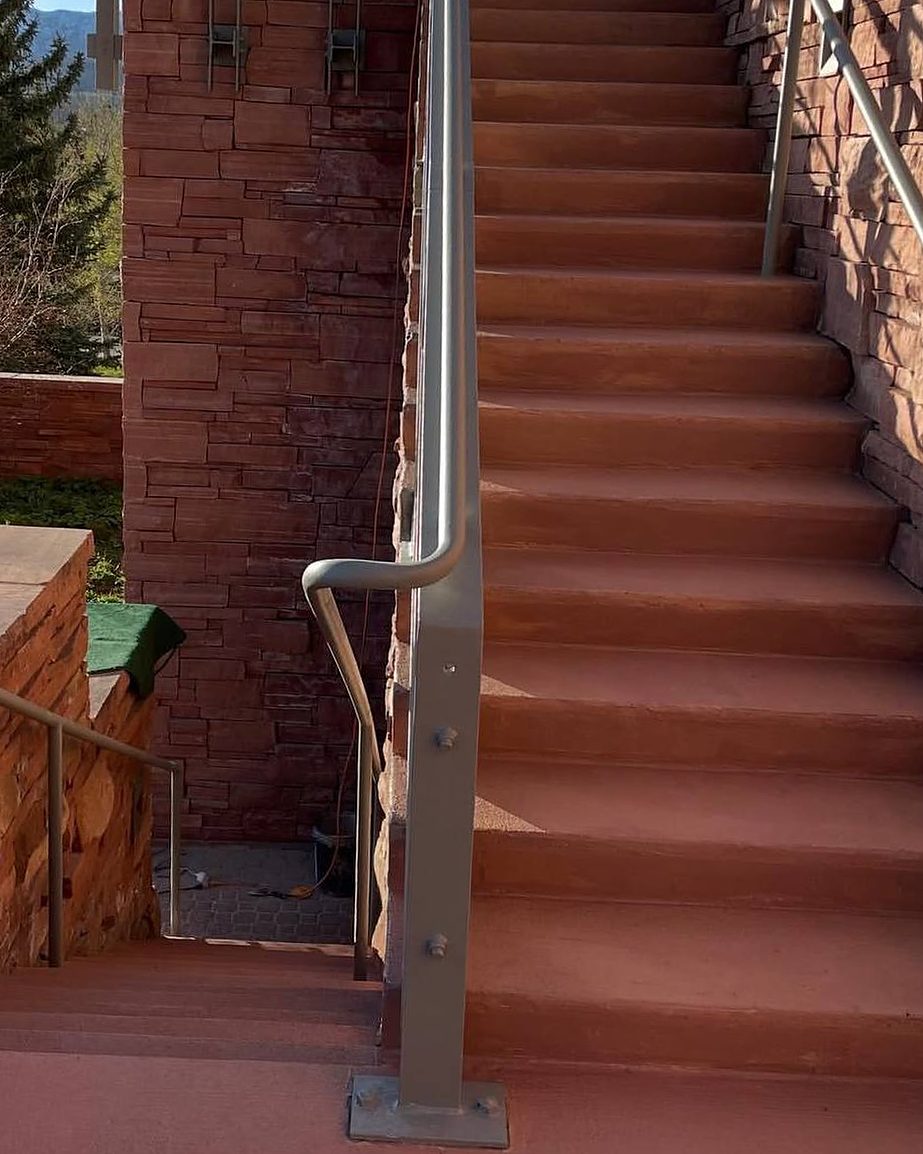 The same stairs after, finished in an even red with a clean railing base